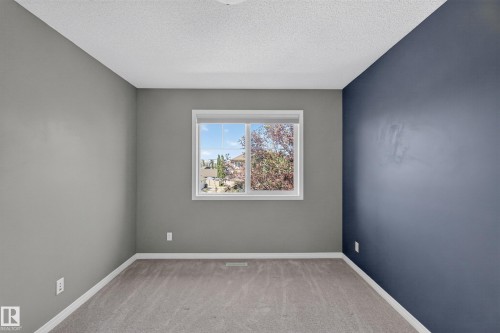 Carpeted room featuring a single window, white baseboards, and a textured ceiling - 3139 Carpenter Landing Sw, Edmonton, AB - Indoor Photo Showing Other Room