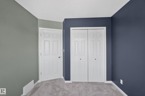 Plush carpeted flooring, white trim, and a bi-fold closet door - 3139 Carpenter Landing Sw, Edmonton, AB - Indoor