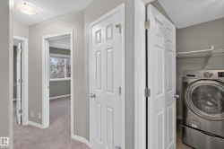 Dedicated laundry area featuring a front-loading washing machine, wire shelving, and wood-finish flooring - 