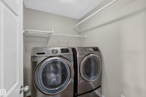 Dedicated laundry area featuring a white wire shelf, a clothes hanging rod, and light gray wall paint - 3139 Carpenter Landing Sw, Edmonton, AB - Indoor Photo Showing Laundry Room
