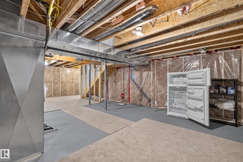Unfinished lower level featuring exposed ceiling joists, ductwork, and framed walls - 3139 Carpenter Landing Sw, Edmonton, AB - Indoor Photo Showing Basement