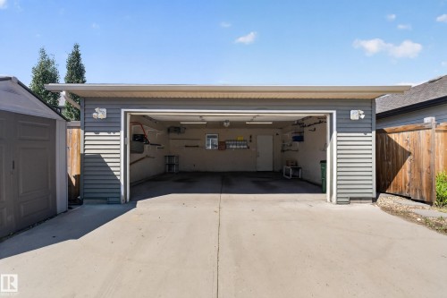 Detached garage with horizontal siding, concrete driveway, and interior overhead lighting - 3139 Carpenter Landing Sw, Edmonton, AB - Outdoor With Exterior