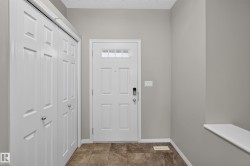 Entryway featuring a paneled door with transom window, tile flooring, and integrated bi-fold closet doors - 