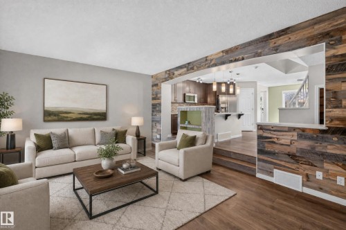 Reclaimed wood accent wall and flooring define this living space - 3139 Carpenter Landing Sw, Edmonton, AB - Indoor Photo Showing Living Room