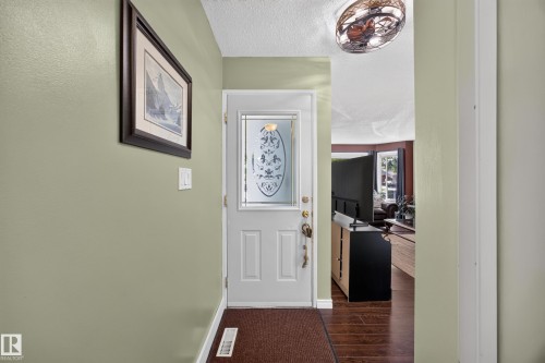 Entryway featuring a white paneled door with decorative glass insert - 8310 99 Avenue, Fort Saskatchewan, AB - Indoor Photo Showing Other Room