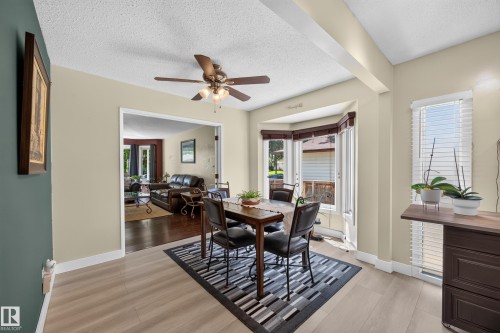 Dining area featuring light wood-finish flooring and a ceiling fan with integrated lighting - 8310 99 Avenue, Fort Saskatchewan, AB - Indoor Photo Showing Dining Room
