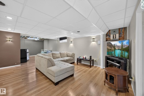 Spacious finished basement featuring wood-finish flooring, recessed lighting, and a drop ceiling - 8310 99 Avenue, Fort Saskatchewan, AB - Indoor