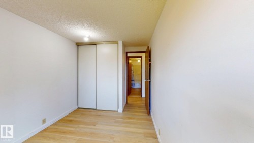 Light wood-finish flooring complements the neutral wall tones - 4912 34A Avenue, Edmonton, AB - Indoor Photo Showing Other Room