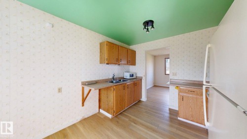 Kitchenette featuring wood-finish flooring, wood cabinetry, a double basin sink, and laminate countertops - 4912 34A Avenue, Edmonton, AB - Indoor Photo Showing Other Room