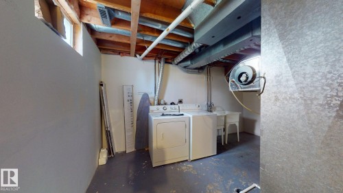 Dedicated laundry area featuring a utility sink, exposed ceiling beams, and a window - 4912 34A Avenue, Edmonton, AB - Indoor Photo Showing Laundry Room