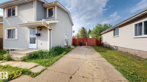 Property exterior featuring light-colored siding and a concrete driveway - 4912 34A Avenue, Edmonton, AB - Outdoor With Exterior