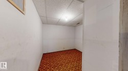 Room featuring patterned carpeting, white walls, drop ceiling, and overhead lighting - 