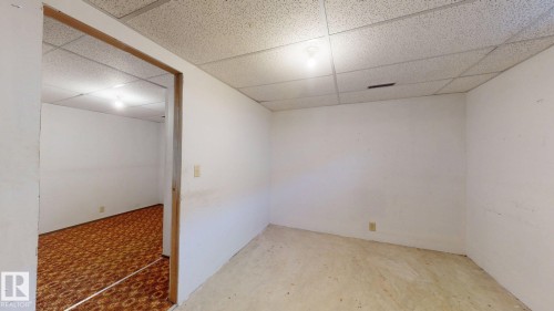 Spacious interior room with light-colored walls, a drop ceiling, and overhead lighting - 4912 34A Avenue, Edmonton, AB - Indoor Photo Showing Other Room