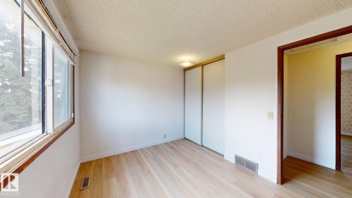 Bright room featuring large windows, wood-finish flooring, and white walls - 4912 34A Avenue, Edmonton, AB - Indoor Photo Showing Other Room