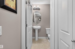 Pedestal sink with an oval mirror and two-light vanity fixture - 
