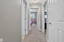 Interior hallway featuring neutral-toned carpet flooring and painted walls - 