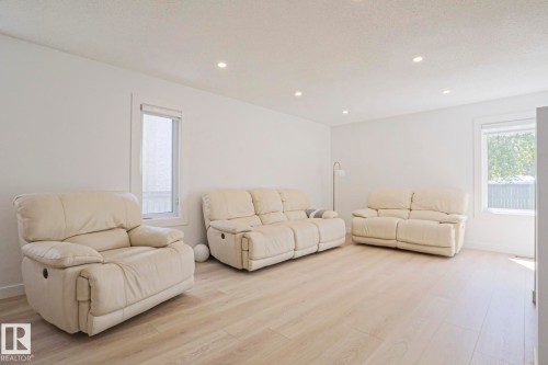 Expansive room featuring light wood-finish flooring, recessed ceiling lighting, and two windows with blinds - 11347 10 Avenue, Edmonton, AB - Indoor Photo Showing Living Room