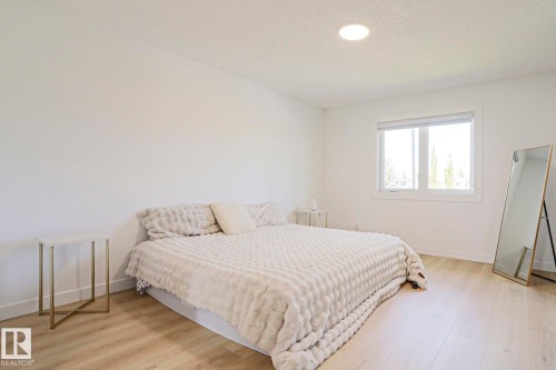 Bright room featuring recessed lighting, light wood-finish flooring, white walls, and a large window - 11347 10 Avenue, Edmonton, AB - Indoor Photo Showing Bedroom