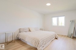 Bright room featuring recessed lighting, light wood-finish flooring, white walls, and a large window - 