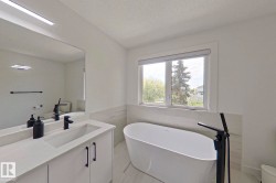 Freestanding soaking tub with a floor-mounted matte black faucet - 