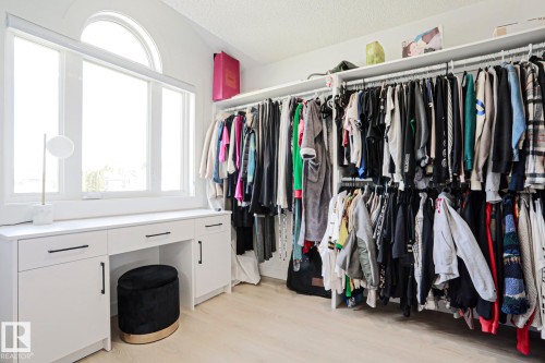 Custom built-in closet system featuring extensive hanging rods and integrated shelving - 11347 10 Avenue, Edmonton, AB - Indoor Photo Showing Bedroom