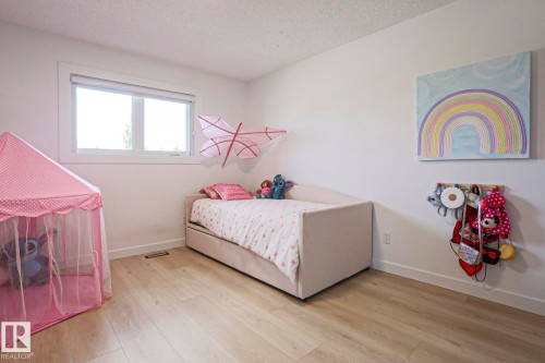 Bright room featuring light wood-finish flooring and a single window with white trim - 11347 10 Avenue, Edmonton, AB - Indoor Photo Showing Other Room