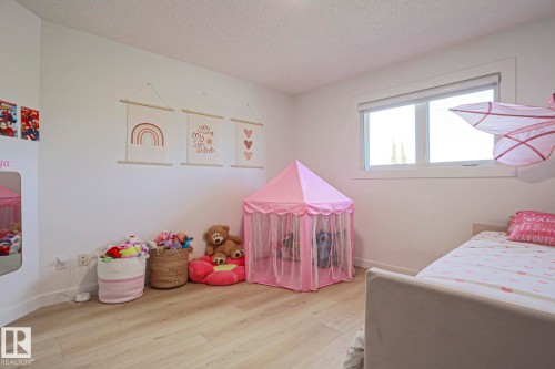Bright room featuring wood-finish flooring, white walls, and a large window with white trim - 11347 10 Avenue, Edmonton, AB - Indoor Photo Showing Bathroom