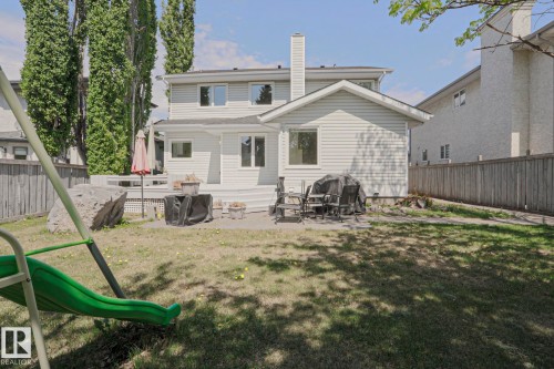 Expansive backyard featuring a multi-level deck, mature trees, and a wooden privacy fence - 11347 10 Avenue, Edmonton, AB - Outdoor