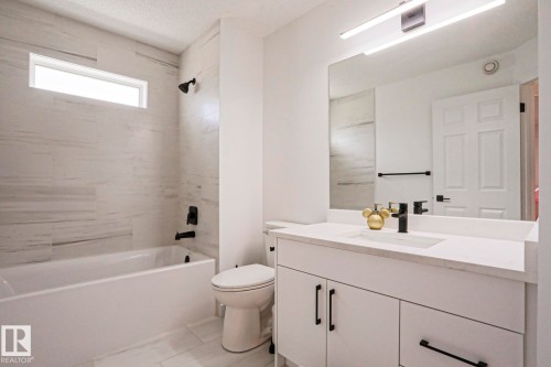 Modern bathroom featuring a white vanity with integrated sink and matte black fixtures - 11347 10 Avenue, Edmonton, AB - Indoor Photo Showing Other Room