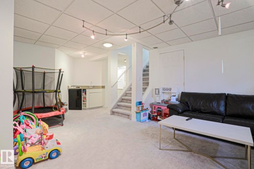 Versatile lower-level space featuring light-toned carpeting and a drop ceiling - 11347 10 Avenue, Edmonton, AB - Indoor Photo Showing Other Room