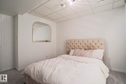 Recessed lighting illuminates this room, featuring carpet flooring, painted walls, and a tiled ceiling - 