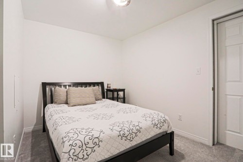 White walls, gray carpet flooring, white baseboards, and a white interior door - 11347 10 Avenue, Edmonton, AB - Indoor Photo Showing Basement
