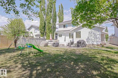 Expansive backyard featuring a manicured lawn, established trees, a fenced perimeter, and a patio area with hardscaping - 11347 10 Avenue, Edmonton, AB - Outdoor