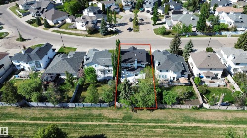 Aerial overview highlighting a residential property with a dark roof and a spacious backyard featuring mature trees - 11347 10 Avenue, Edmonton, AB - Outdoor With View