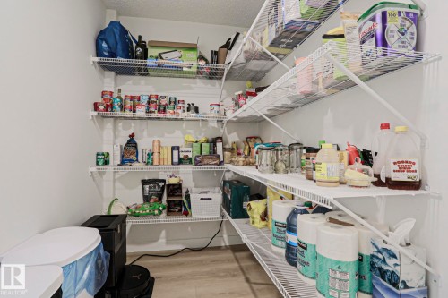 Walk-in pantry featuring white wire shelving, light wood-finish flooring, and white painted walls - 11347 10 Avenue, Edmonton, AB - Indoor With Storage