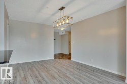 Dining area featuring wood-finish flooring, a contemporary linear chandelier - 