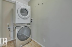 Dedicated laundry area featuring a stacked washer and dryer - 