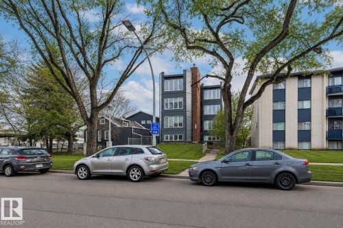 Modern multi-story building featuring dark gray siding and multiple large windows - #201 10743 107 St Nw, Edmonton, AB - Outdoor