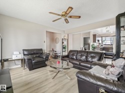 Spacious living area featuring light wood-finish flooring and neutral wall tones - 