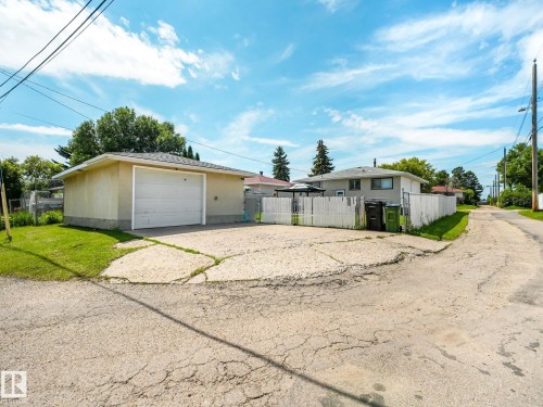 Detached garage with a white overhead door and shingle roof, set on a concrete pad - 13323 58 Street Nw, Edmonton, AB - Outdoor