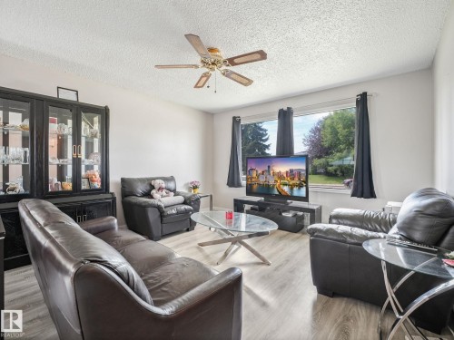 Living area featuring light wood-finish flooring, white walls, and a ceiling fan with integrated lighting - 13323 58 Street Nw, Edmonton, AB - Indoor Photo Showing Living Room