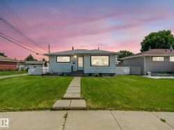 Light blue siding home featuring a dark shingle roof, white trim windows, and a concrete paver walkway - 