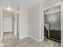 Hallway featuring light wood-finish flooring, white baseboards, and neutral wall paint - 