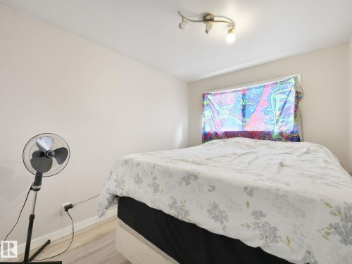Neutral-toned walls complement wood-finish flooring - 13323 58 Street Nw, Edmonton, AB - Indoor Photo Showing Bedroom
