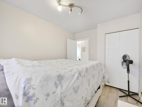 Bedroom featuring light-toned walls, track lighting, and wood-finish flooring - 13323 58 Street Nw, Edmonton, AB - Indoor Photo Showing Bedroom
