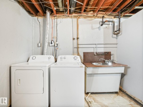 Laundry area with exposed ceiling joists, utility sink, and floor drain - 13323 58 Street Nw, Edmonton, AB - Indoor Photo Showing Laundry Room