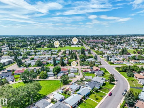 Aerial perspective showcasing a residential neighborhood with established homes, green spaces, and connecting roadways - 13323 58 Street Nw, Edmonton, AB - Outdoor With View