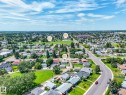 Aerial perspective showcasing a residential neighborhood with established homes, green spaces, and connecting roadways - 13323 58 Street Nw, Edmonton, AB  - Outdoor With View 