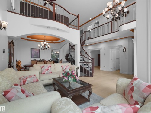 Grand foyer featuring a spiral staircase with wood newel posts and metal spindles - 3136 35 Avenue Nw, Edmonton, AB - Indoor Photo Showing Living Room