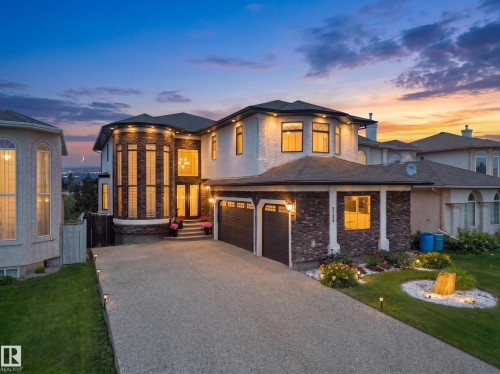 Stunning multi-story residence featuring a distinctive turret with floor-to-ceiling windows, a spacious concrete driveway, and an integrated two-car garage - 3136 35 Avenue Nw, Edmonton, AB - Outdoor